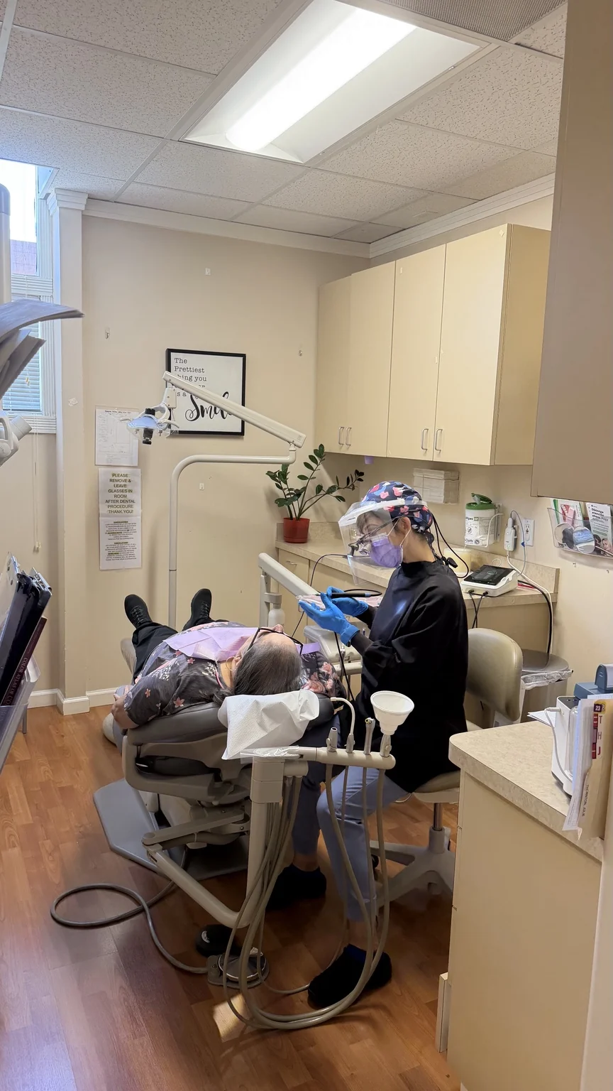 A dental professional providing patient care in a treatment room
